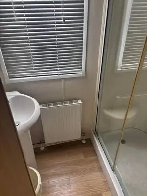 a bathroom with a toilet and a sink and a shower at Clarach Bay Escape 3 Bedroom PetFriendly Caravan with Decking Sleeps 6 in Aberystwyth