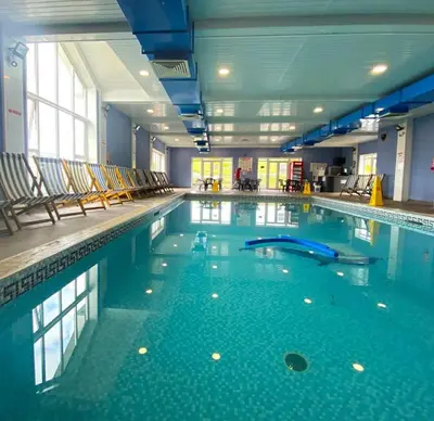 a large swimming pool with chairs in a building at Clarach Bay Escape 3 Bedroom PetFriendly Caravan with Decking Sleeps 6 in Aberystwyth