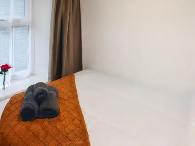 a bed with a pair of gray towels on it at Apartment Two - Uk49592 in Bala