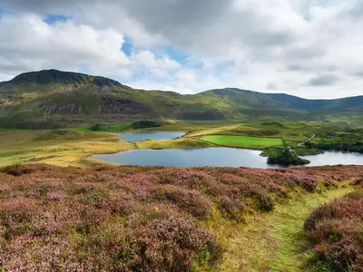 a golf course with a lake and mountains in the background at Apartment Two - Uk49592 in Bala