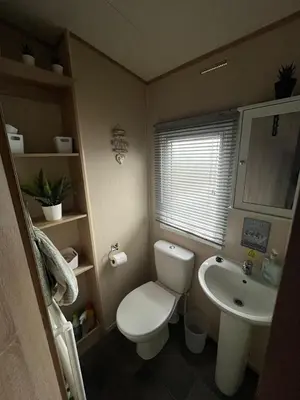 a small bathroom with a toilet and a sink at Gold Plus 3 Bed ABI Summer Breeze Modern Caravan with Sea View Pet Friendly in Aberystwyth