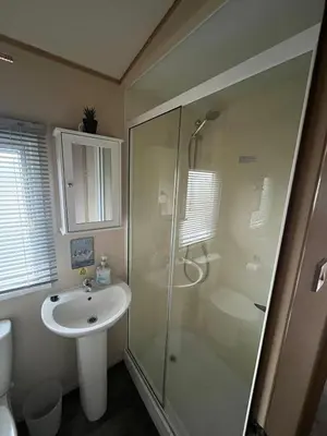 a bathroom with a glass shower and a sink at Gold Plus 3 Bed ABI Summer Breeze Modern Caravan with Sea View Pet Friendly in Aberystwyth