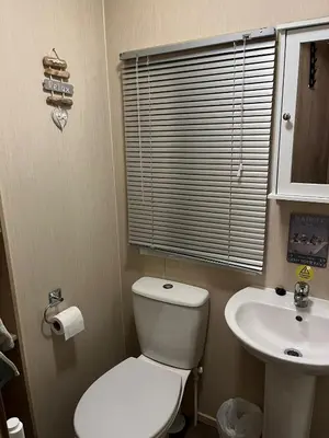 a small bathroom with a toilet and a sink at Gold Plus 3 Bed ABI Summer Breeze Modern Caravan with Sea View Pet Friendly in Aberystwyth
