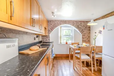 a kitchen with wooden cabinets and a table with a counter top at 2 Bed in Defynnog oc-t32724 in Sennybridge