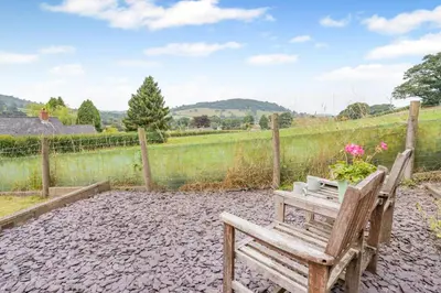 a wooden bench sitting in front of a fence at 2 Bed in Defynnog oc-t32724 in Sennybridge