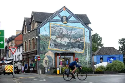 a person riding a bike in front of a building with a mural at 1 Bed in Garth oc-h32701 in Garth