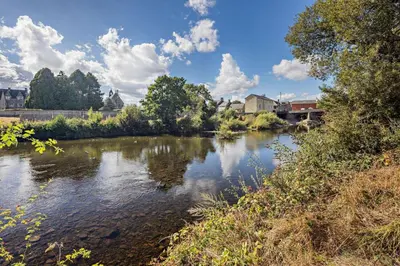 a river with trees and buildings in the background at 2 Bed in Brecon oc-t32728 in Brecon
