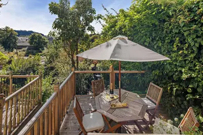 a wooden deck with a table and an umbrella at 2 Bed in Brecon oc-t32728 in Brecon