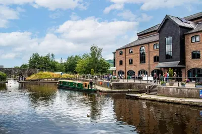 a boat in a river in front of a building at 2 Bed in Brecon oc-t32728 in Brecon