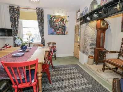 a dining room with a wooden table and red chairs at Bryn Dwr in Llangollen