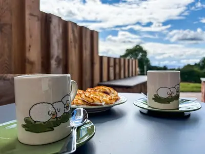 two coffee cups and a plate of food on a table at Shropshire Way Stay in Farden