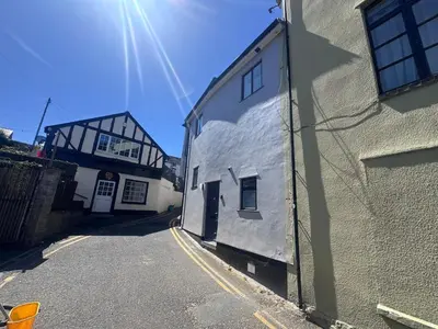 an alley with a white building next to a street at 4 Bedroom All En suite Central Townhouse Ideal for Groups in Builth Wells