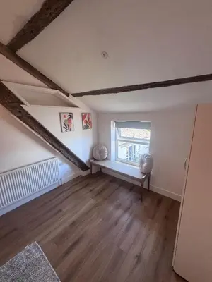 an empty living room with a window and wooden floors at 4 Bedroom All En suite Central Townhouse Ideal for Groups in Builth Wells