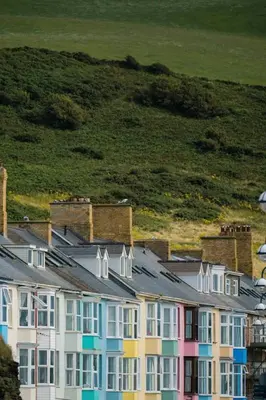 a row of colorful houses with a hill in the background at The Granary Aberystwyth in Aberystwyth