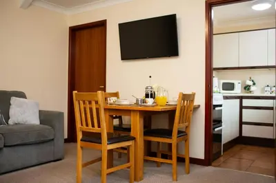 a living room with a wooden table and chairs at The Granary Aberystwyth in Aberystwyth