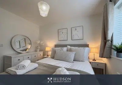a bedroom with a large bed and a mirror at 3 Bed Stylish Shrewsbury Home in Shrewsbury