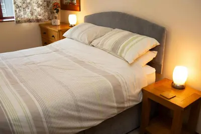 a bedroom with a bed with two candles on tables at The Stable Aberystwyth in Aberystwyth
