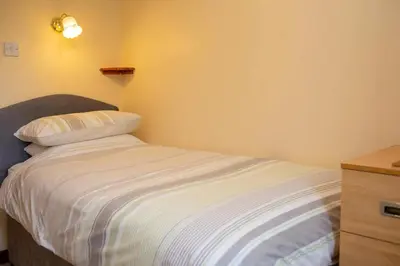 a small bedroom with a bed and a dresser at The Stable Aberystwyth in Aberystwyth