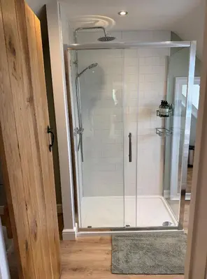 a shower with a glass door in a bathroom at Minafon Loft in Meifod