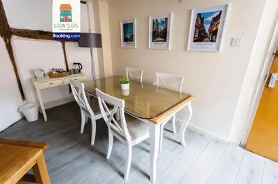 a dining room with a glass table and white chairs at Spacious 5 Family Rooms House By Shropshire Escapes Short Lets & Serviced Accommodation Shrewsbury With Free WiFi in Shrewsbury