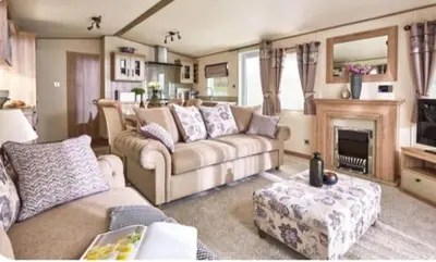 a living room with a couch and a fireplace at Lodge - Sleeps 4 Near beach & Free parking in Llanina