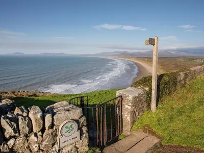 a gate on a hill next to a beach at Platinum Lodge 503 in Talybont