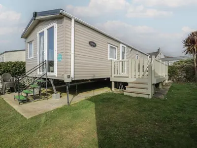 a tiny house with a staircase and a deck at Gold Caravan 316 in Talybont