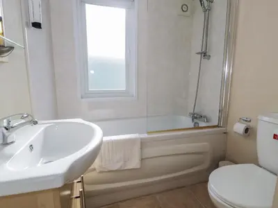 a bathroom with a sink and a tub and a toilet at Gold Lodge 201 in Talybont