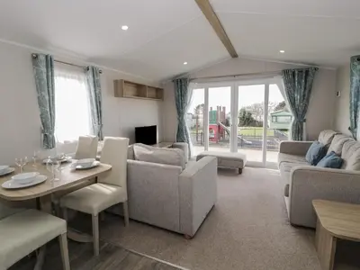 a living room with a couch and a table and chairs at Gold Caravan 203 in Talybont