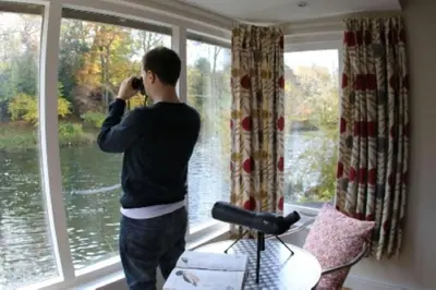 a man talking on a cell phone in front of a window at The Studio, spacious riverside property in Ludlow with private parking in Ludlow
