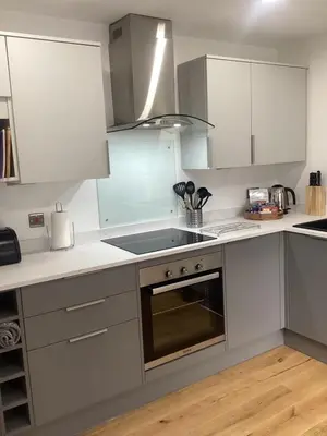 a kitchen with white cabinets and a stove top oven at The Studio, spacious riverside property in Ludlow with private parking in Ludlow