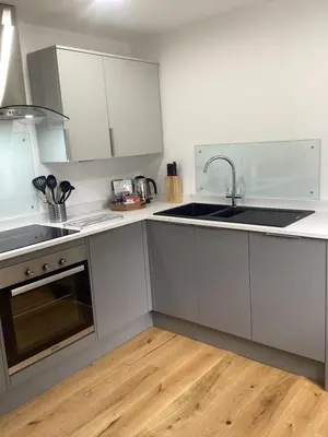 a kitchen with white cabinets and a sink at The Studio, spacious riverside property in Ludlow with private parking in Ludlow