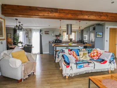 a living room with a couch and a kitchen at Coogee View in New Quay