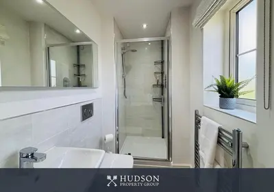 a bathroom with a white sink and a shower at 3 Bedroom Home Near Shrewsbury