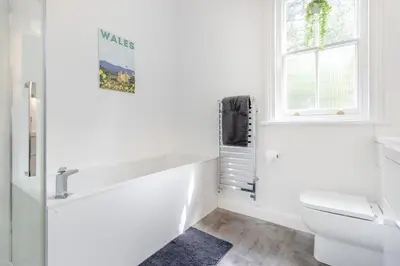 a white bathroom with a tub and a toilet at 3 Bed in Cyfronydd oc-e32742 in Llanfair Caereinion
