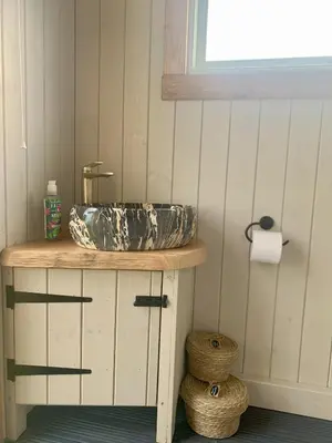 a bathroom sink sitting on top of a counter at Tower Farm Holidays - Shepherd's Huts in Llangollen
