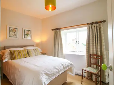 a bedroom with a bed and a window and a chair at 41 High Street in Bishops Castle
