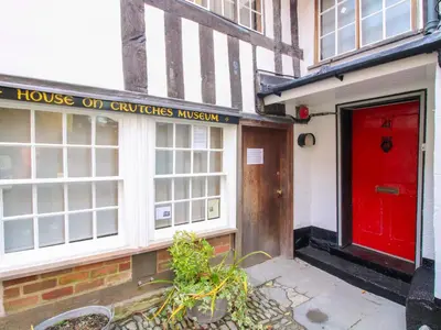 a building with a red door and a house on quilts museum at 41 High Street in Bishops Castle