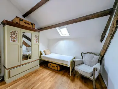 a small room with a bed and a chair at Ty Isaf Welsh Farmhouse with Sea Views in Llanddwywe