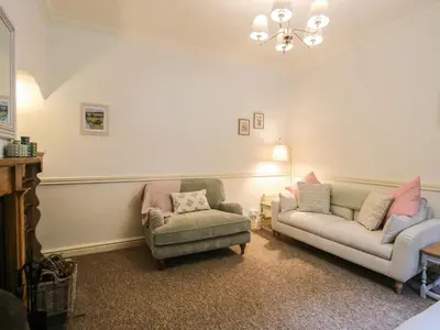 a living room with a couch and a chair at 2 Aqueduct Cottages in Wrexham