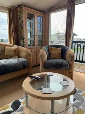 a living room with couches and a coffee table at Beach Retreat in Ynys-lâs Station
