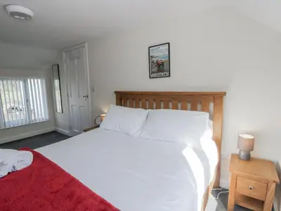 a bedroom with a large white bed with a red blanket at Glandwr House in Llandrindod Wells