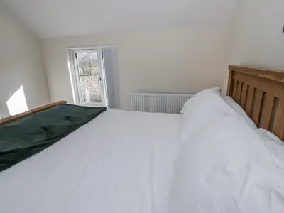 a white bed in a room with a window at Glandwr House in Llandrindod Wells