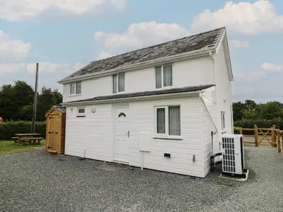 a white house with a garage at Glandwr House in Llandrindod Wells