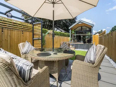 a patio with a table and chairs and an umbrella at Aqueduct Hideaway in Llangollen