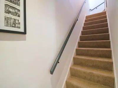 a staircase in a house with a black rail at Raven Lane Retreat in Ludlow