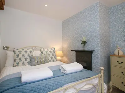 a bedroom with a bed with blue patterned walls at Raven Lane Retreat in Ludlow
