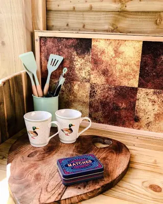 a table with two cups and utensils on a wooden table at Taylor the Burt in Penuwch