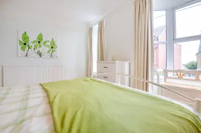 a bedroom with a bed with a green blanket at 4 Bed in Barmouth oc-n32921 in Barmouth
