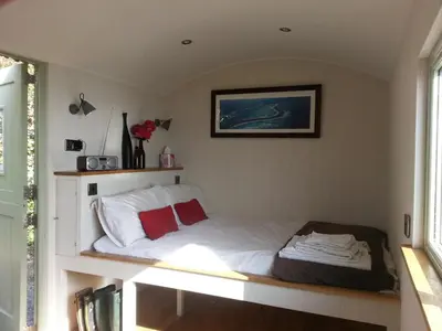 a bed in a small room with a window at The Farm Hut in Barmouth